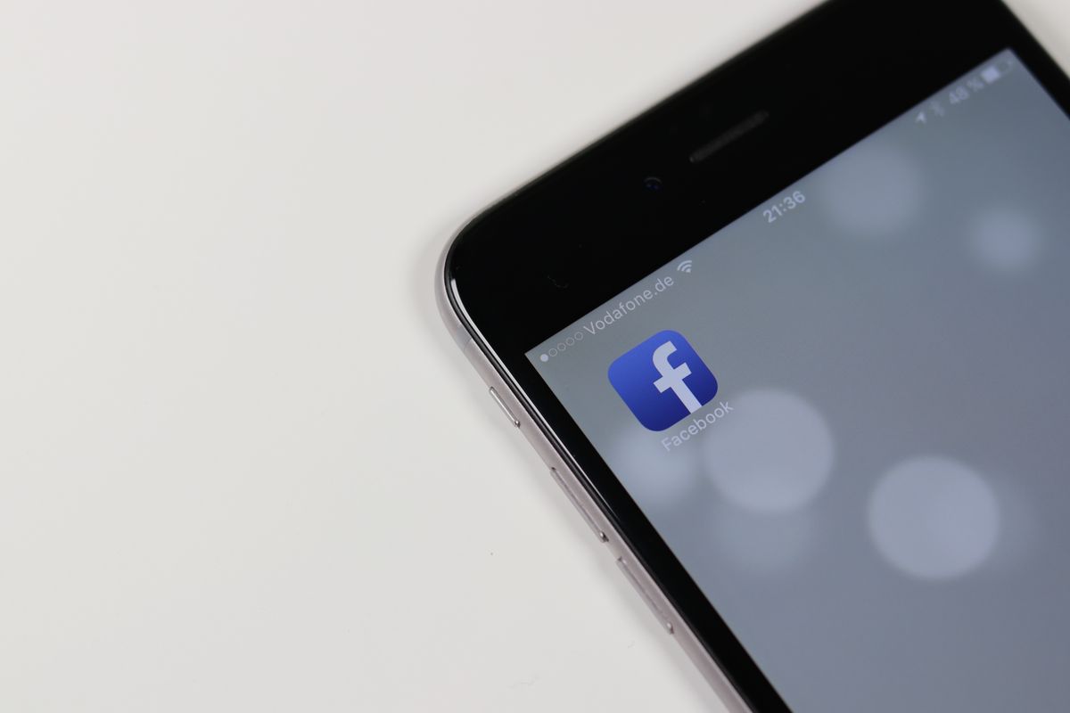 Smartphone screen displaying the Facebook app icon, representing Facebook post formatting